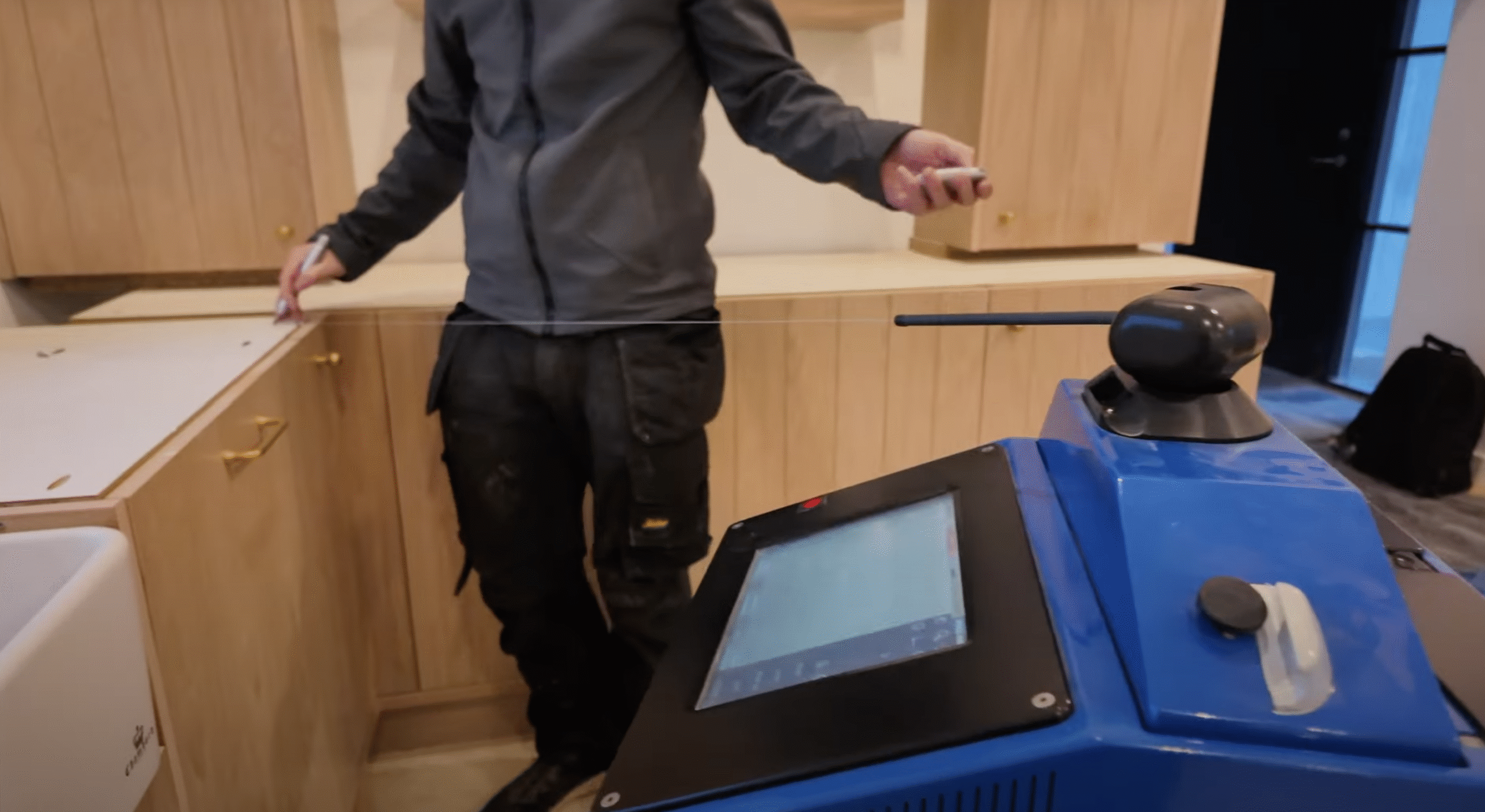 Technician using laser templating device for kitchen worktop measurement