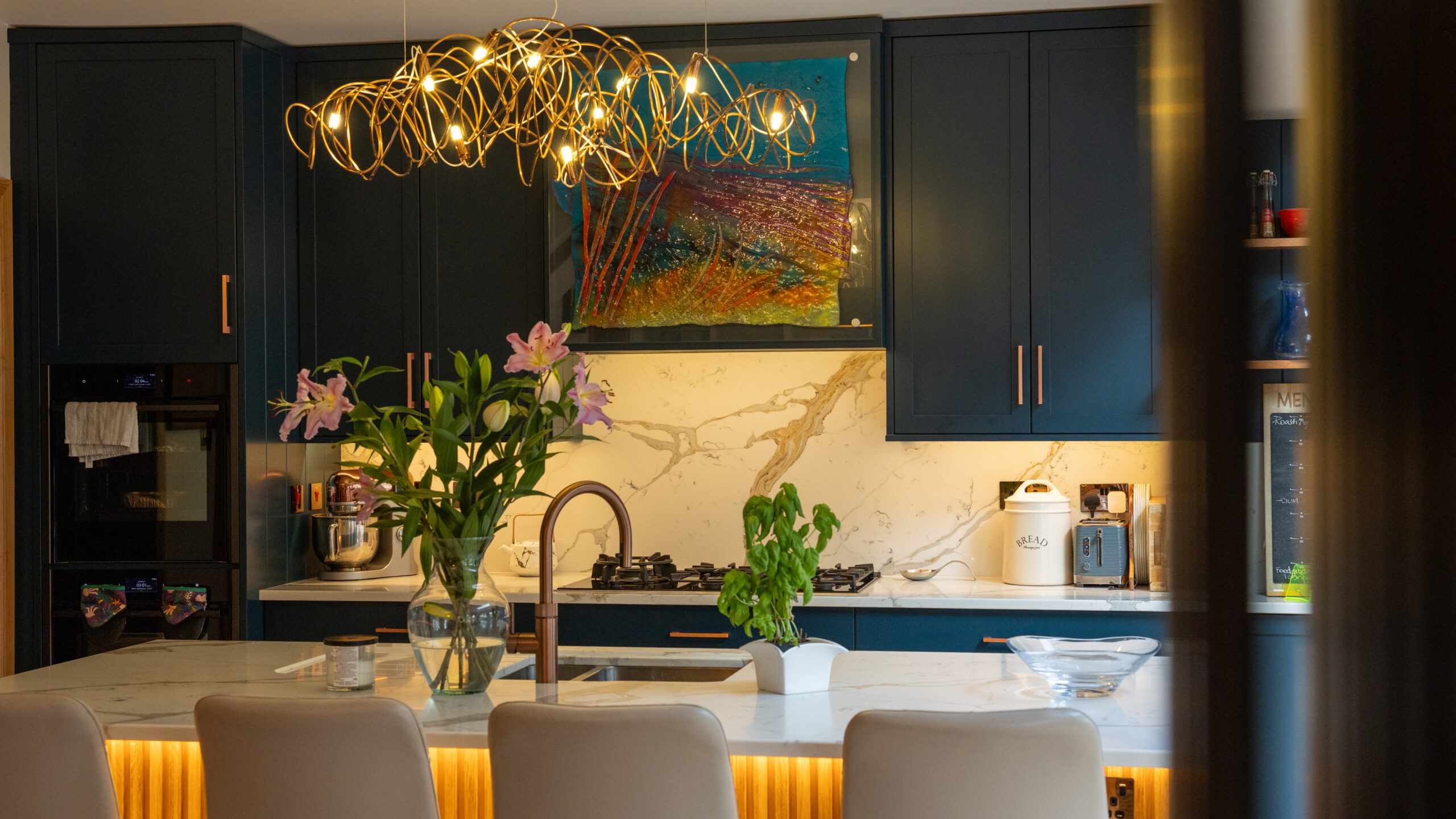 Dark teal shaker kitchen with Calacatta quartz splashback, island and gold pendant light